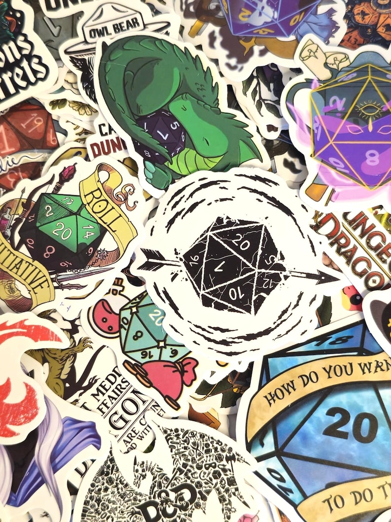 May include: A collection of colorful stickers featuring fantasy and role-playing game themes. Designs include dice, dragons, and text like "Dungeons & Dragons" and "Roll". The stickers vary in size and shape, with a mix of illustrations and text.