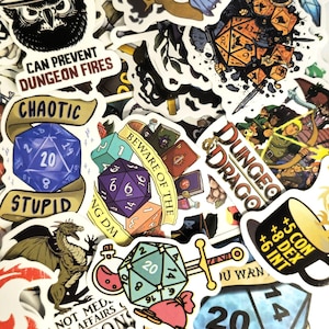 May include: A collection of colorful stickers with a fantasy theme. Designs include dice, dragons, swords, and text like "Dungeon Fires" and "Chaotic". The stickers are various shapes and sizes, with a white border.