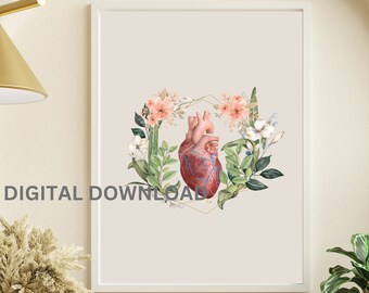 May include: A framed wall art print featuring a realistic anatomical human heart centered within a delicate gold geometric frame, surrounded by watercolor-style illustrations of soft pink flowers and lush green foliage on a light beige background.