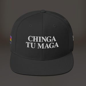 K&ouml;nnte beinhalten: Schwarze Baseballkappe mit einem wei&szlig;en gestickten Spruch "CHINGA TU MAGA" und einer kleinen Regenbogenflagge an der Seite.