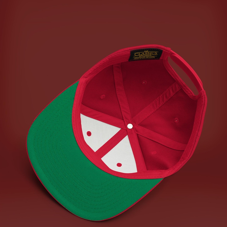 K&ouml;nnte beinhalten: Rote und gr&uuml;ne Baseballkappe mit wei&szlig;em Innenfutter. Die Kappe hat ein klassisches Design und einen gebogenen Schirm.
