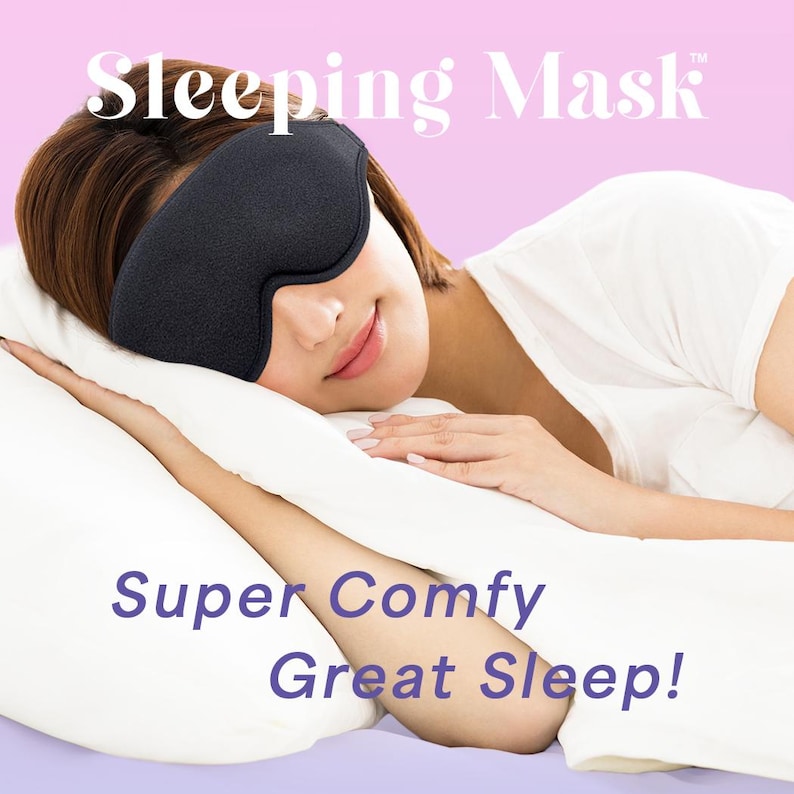 May include: A black sleeping mask is worn by a person lying on a white pillow. The text "Sleeping Mask" is at the top of the image, with "Super Comfy Great Sleep!" below. The mask covers the eyes.