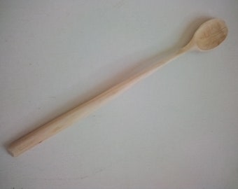 May include: A light-coloured wooden spoon with a long handle and a rounded bowl. The spoon is made of unfinished wood and appears to be handmade. The spoon is likely used for cooking or serving.