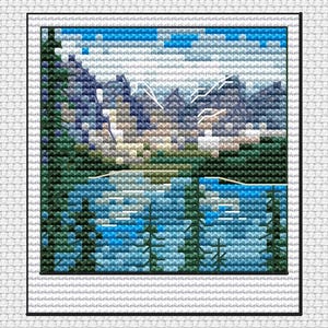 May include: A cross-stitch landscape featuring a mountain range reflected in a lake. The scene uses shades of blue, green, and white to depict the sky, water, trees, and mountains. The artwork is framed with a black border.