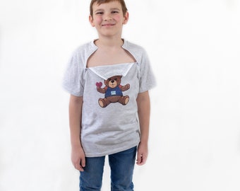 May include: A gray t-shirt with a split front, revealing a white undershirt. The t-shirt features a cartoon teddy bear wearing a blue shirt and holding a red heart.