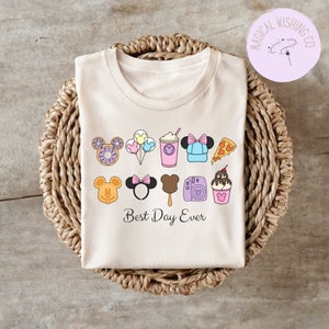 Może przedstawiać: Jasnoszary t-shirt z grafiką przedstawiającą r&oacute;żne ikony związane z Disneyem, w tym uszy Myszki Miki, pączek, balony, nap&oacute;j, czapkę, kawałek pizzy, loda na patyku, aparat fotograficzny i lody. Pod ikonami znajduje się napis "Best Day Ever".