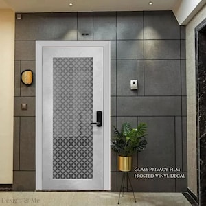 May include: A white door with a black geometric pattern in the glass panel. The door has a black handle and is set against a gray tiled wall. Text on the right reads "GLASS PRIVACY FILM FROSTED VINYL DECAL."