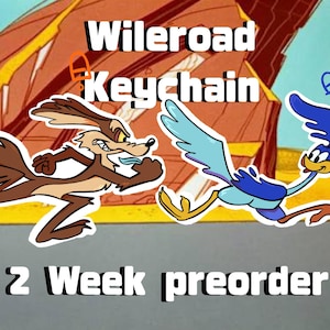 May include: A keychain featuring a brown coyote and a blue roadrunner character in a running pose. The text "Wileroad Keychain" is displayed above the characters, and "2 Week preorder" is printed at the bottom of the image.