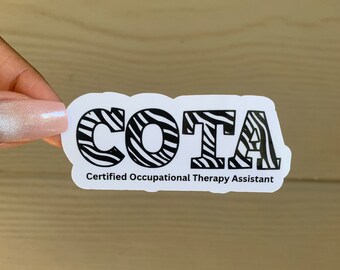 Può includere: Un adesivo bianco con lettere nere a stampa zebrata che recita "COTA" e "Certified Occupational Therapy Assistant".