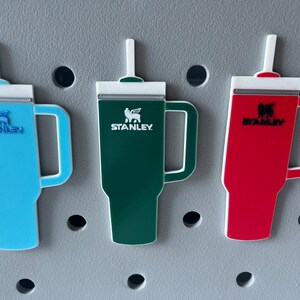 A close up view of the Stanley tumbler charms attached to a bogg bag.