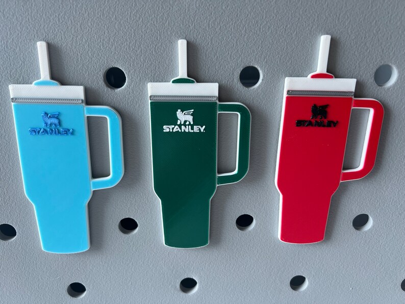 A close up view of the Stanley tumbler charms attached to a bogg bag.