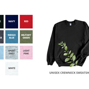 May include: A black unisex crewneck sweatshirt with a leafy green branch design. The sweatshirt is available in a variety of colors, including black, navy, red, dark heather, indigo blue, military green, light blue, sport grey, light pink, and white.