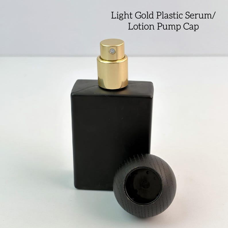 May include: A black rectangular bottle with a light gold pump cap and a separate dark wooden cap. The text "Light Gold Plastic Serum/ Lotion Pump Cap" is visible at the top. The bottle is on a white surface.