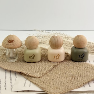 Può includere: Quattro bottiglie decorative a forma di fungo. Una è trasparente con un tappo di legno e la scritta "Get Rich". Le altre tre sono di colori pastello con tappi di legno e disegni floreali. Ognuna ha la parola "Luck" stampata.