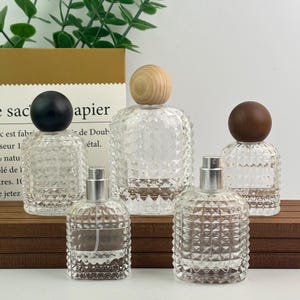 Frascos de vidrio con atomizador de 30 ml/50 ml, recargables con tapa esférica de madera, ideales para perfumes caseros o como recipiente para cosméticos y maquillaje.
