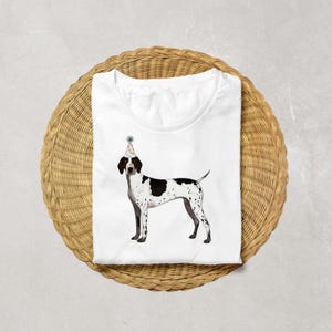 May include: White t-shirt with a black and white illustration of a German Shorthaired Pointer wearing a party hat.