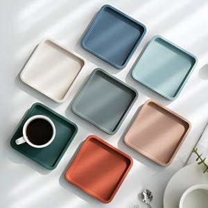 May include: Set of six square silicone trays in various colours, including beige, light blue, dark blue, green, pink, and orange. The trays are ideal for organising small items, serving snacks, or holding jewellery.