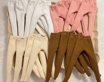 May include: A set of 10 pairs of doll leggings in white, pink, beige, and brown. The leggings are made of a ribbed fabric and have a stretchy fit.