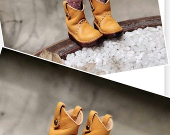 May include: A pair of brown leather cowboy boots with a pointed toe and a stitched design. The boots have a brown leather sole and a brown leather heel.