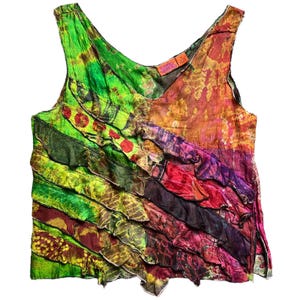May include: A sleeveless, V-neck top with a vibrant, layered design. The top features a mix of colors including green, red, purple, and orange. The fabric has a tie-dye or batik appearance, creating a unique, artistic look. The top is a bohemian style.