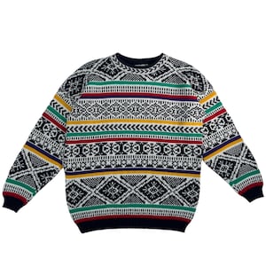 May include: A long-sleeved sweater with a geometric pattern. The sweater features a navy blue base with white, black, red, yellow, green, and purple stripes and diamond shapes. The cuffs and neckline are navy blue.