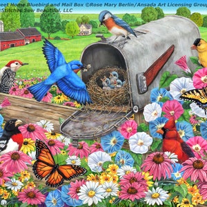 Puede incluir: Un pájaro azul alimenta a sus crías en un nido dentro de un buzón de metal vintage. El buzón está en un poste de madera rodeado de una variedad de flores coloridas, incluyendo rosas, blancas y azules. También se puede ver un cardenal rojo, un jilguero amarillo y una mariposa monarca en la escena.