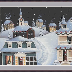 Puede incluir: Patrón de punto de cruz de una escena invernal con un pueblo nevado, casas, una iglesia y un camino sinuoso. Las casas están decoradas con coronas y luces, y la nieve cae contra un cielo nocturno oscuro.