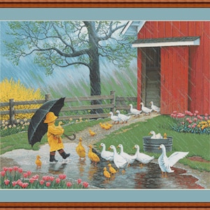 May include: A framed print depicts a child in a yellow raincoat and hat holding a black umbrella, walking through a puddle with ducks and geese. A red barn and a wooden fence are in the background, with rain falling.