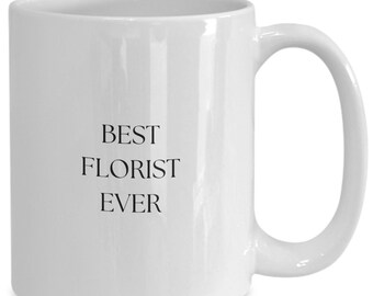 May include: White ceramic mug with a curved handle. The mug features the text "BEST FLORIST EVER" in black, centered on the front. The mug is designed for hot drinks and is suitable for home or office use.