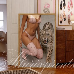May include: A framed print featuring a woman in a pink bikini and knee-high boots posing with a snow leopard. The print is displayed in a room with other framed art and a wooden cabinet. The text "Allurixprints" is visible.