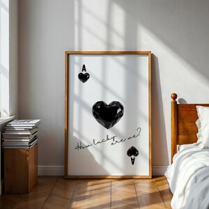 May include: A black and white poster with a large black heart and the text "How lucky are we?"  The heart is a playing card ace of spades.