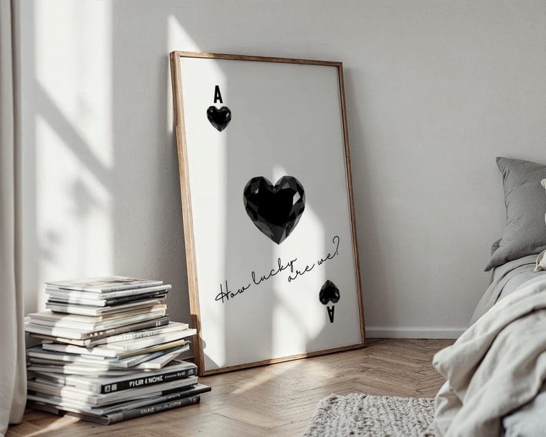 May include: A framed print with a black and white illustration of an ace of spades playing card. The ace of spades is depicted as a black heart with the letter A at the top. The text "How lucky are we?" is written in cursive below the heart.