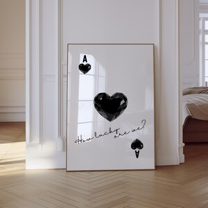 May include: A black and white printable art print with a black ace of spades playing card with a large black heart in the center. The text "How lucky are we?" is written in cursive below the heart.