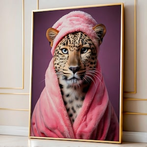 May include: A leopard wearing a pink bathrobe with a hood. The leopard has blue eyes and is looking directly at the camera.