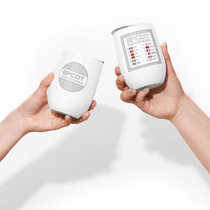 May include: Two white stainless steel wine tumblers with a silver design. One tumbler has the text "EPCOT" and a circle with a pattern. The other tumbler has the text "EPCOT" and a list of countries with flags.