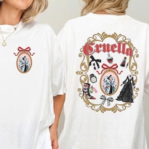 May include: White t-shirt featuring a Cruella design. The front has a small oval portrait with a red bow. The back has a larger design with the word "Cruella" and various related illustrations, including a dress and boots.