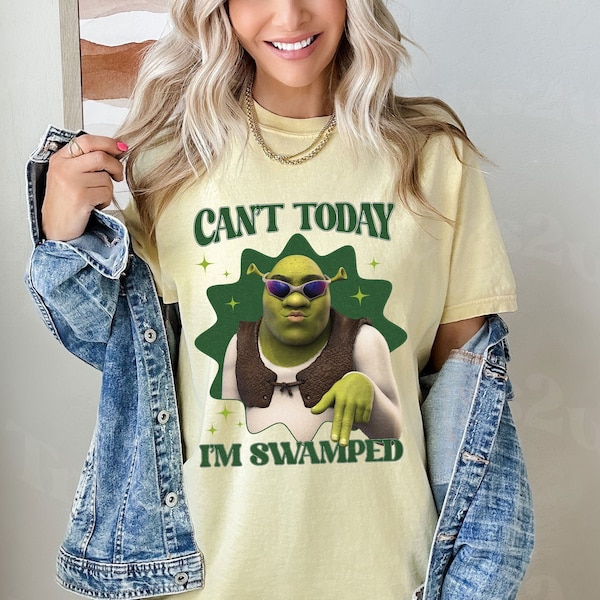 Puede incluir: Una camiseta amarilla con un personaje de dibujos animados verde que lleva gafas de sol y un chaleco. El texto de la camiseta dice "Can't Today I'm Swamped".