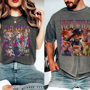 May include: Two grey t-shirts featuring characters from the animated film "Zootropolis." One shirt displays "JUDY HOPPS" with images of Judy Hopps and other characters. The other shirt shows "NICK WILDE" with images of Nick Wilde and other characters.