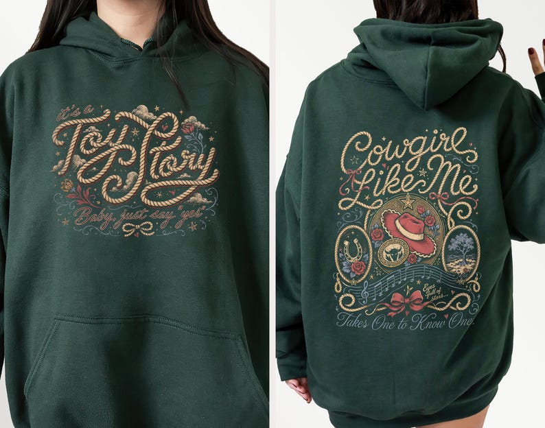 May include: A dark green hooded sweatshirt featuring a graphic on the front that reads "It's a Toy Story, Baby, just say yes" in rope-style lettering. The back displays "Cowgirl Like Me" and "Takes One to Know One" with a cowboy hat and floral art.