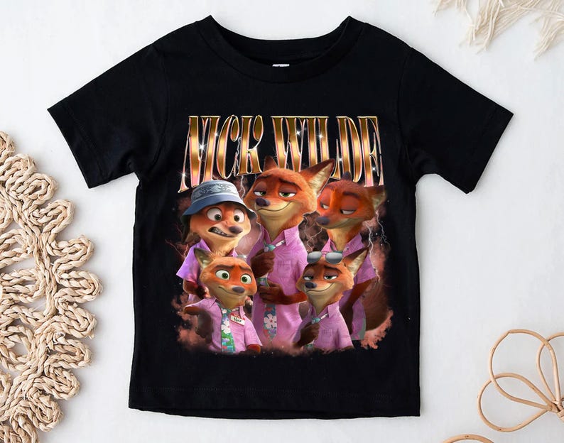 May include: Black t-shirt featuring a graphic of Nick Wilde from Zootopia. The image shows Nick Wilde and other fox characters wearing pink shirts. The text "NICK WILDE" is printed in gold letters above the image.