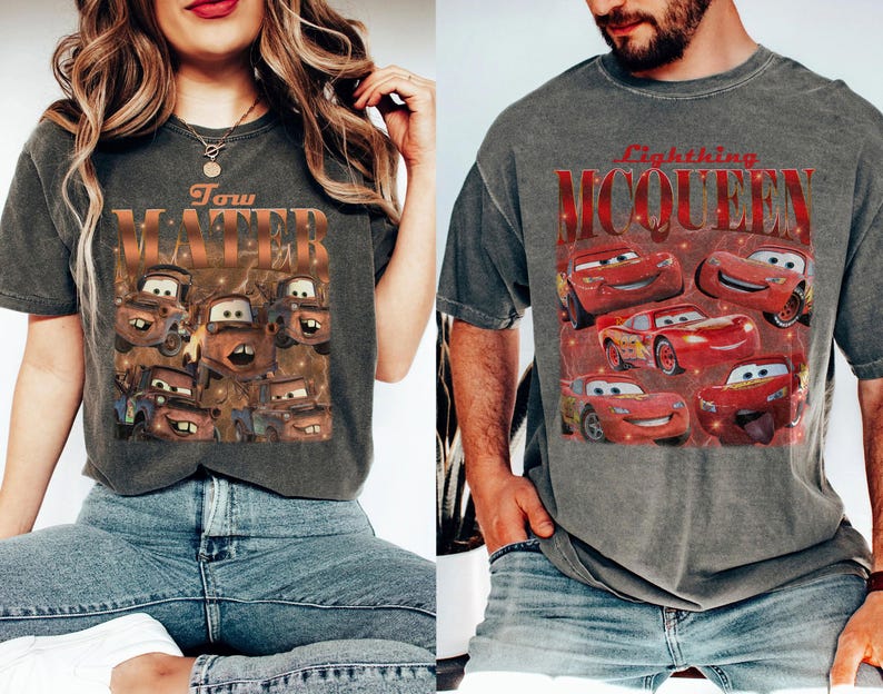 May include: Two gray t-shirts featuring graphics from the animated movie "Cars." One shirt displays Tow Mater with text, while the other showcases Lightning McQueen. Both shirts have a vintage, distressed look.