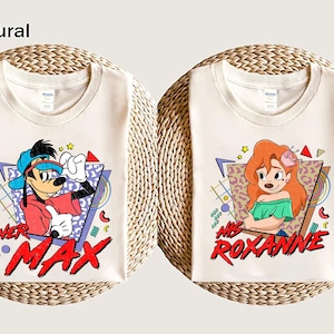 Könnte beinhalten: Zwei weiße T-Shirts mit einem Retro-Design aus den 90er Jahren. Ein Shirt zeigt eine Zeichentrickfigur von Max Goof mit dem Text "Her Max" und das andere Shirt zeigt eine Zeichentrickfigur von Roxanne mit dem Text "His Roxanne".
