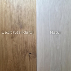 May include: A side-by-side comparison of two wood finishes. On the left, a warm, medium-toned wood labeled "Ge&ouml;lt (Standard)". On the right, a light, almost white wood labeled "Natur". Both have visible wood grain.