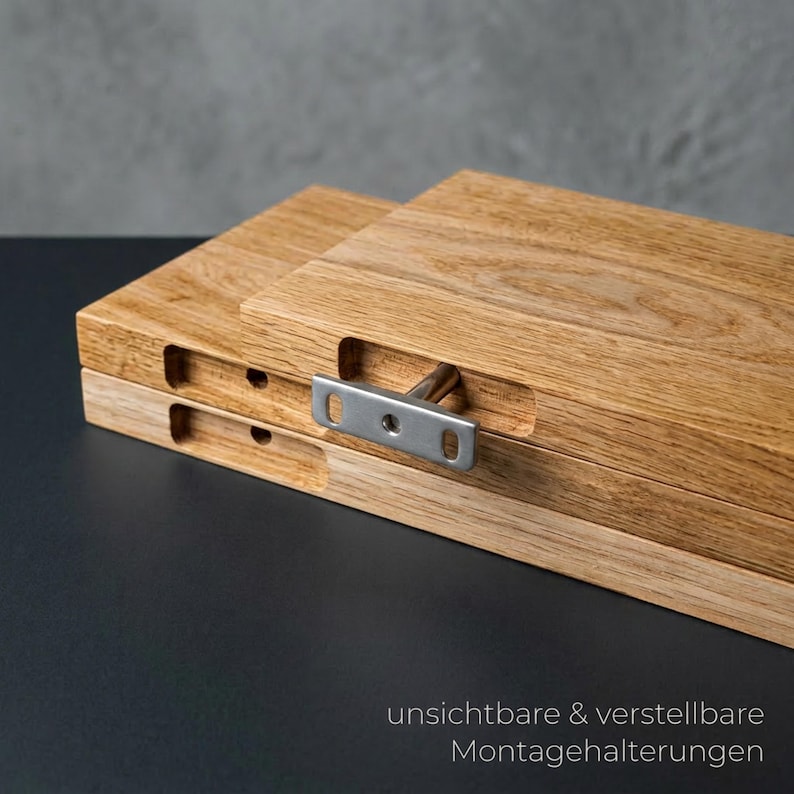 May include: Close-up of two wooden planks with a natural wood grain finish. A metal bracket is attached to the planks, with the text "unsichtbare & verstellbare Montagehalterungen" in the bottom right corner.
