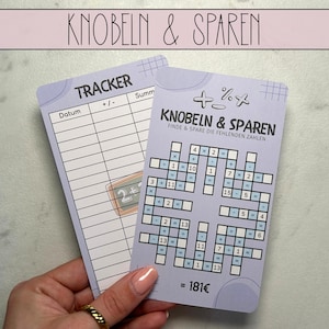 Può includere: Un tracker stampabile viola e blu e un gioco di puzzle stampabile viola e blu con il testo "Knobeln & Sparen" e "Finde & Spare die fehlenden Zahlen". Il gioco di puzzle ha una griglia con numeri e simboli matematici. Il tracker ha una colonna per la data, più o meno e la somma.