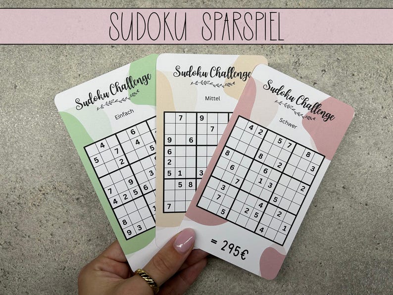May include: Three Sudoku puzzle cards with different difficulty levels: Easy, Medium, and Hard. The cards are pink and green with a floral design and the text "Sudoku Challenge".
