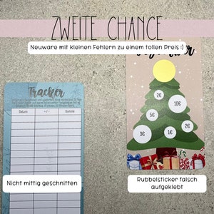 May include: A blue and white tracker with a grid for tracking dates, amounts, and totals. The tracker is labelled "Tracker". A Christmas tree with a yellow star on top and various price stickers on the branches. The text "Zweite Chance" is at the top of the image. The text "Neuware mit kleinen Fehlern zu einem tollen Preis :)" is below the text "Zweite Chance". The text "Nicht mittig geschnitten" is below the tracker. The text "Rubbelsticker falsch aufgeklebt" is below the Christmas tree.
