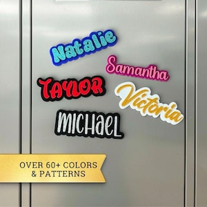 May include: A collection of colorful name magnets spelling out "Natalie", "Samantha", "Taylor", "Michael", and "Victoria". The names are in various fonts and colors, including blue glitter, pink, red, and white. The image also includes text that says "OVER 60+ COLORS & PATTERNS".