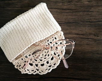 May include: A crocheted eyeglass case with a delicate lace design and a pair of rose gold eyeglasses.