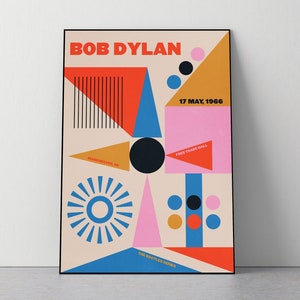 Puede incluir: Un póster de estilo retro para un concierto de Bob Dylan en Manchester, Reino Unido, el 17 de mayo de 1966 en el Free Trade Hall. El póster presenta formas geométricas en rojo, naranja, amarillo, azul, rosa y negro.